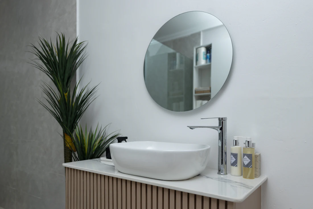 Round backlit mirror above a bathroom vanity